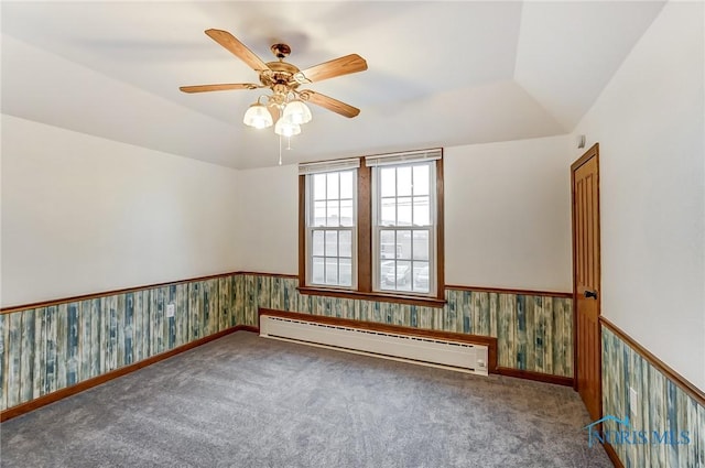 spare room featuring baseboard heating, ceiling fan, carpet flooring, and vaulted ceiling