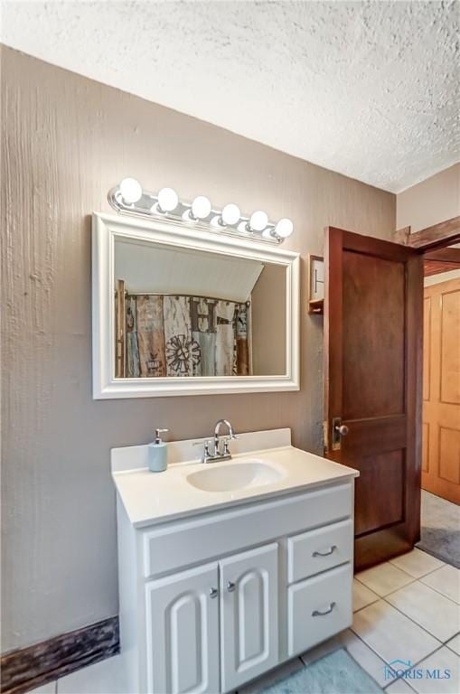 bathroom featuring tile patterned flooring, vanity, and a textured ceiling