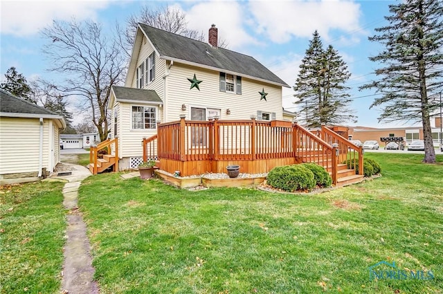 rear view of property with a deck and a lawn