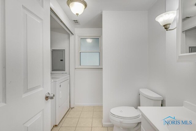 bathroom with washing machine and dryer, tile patterned floors, electric panel, toilet, and vanity