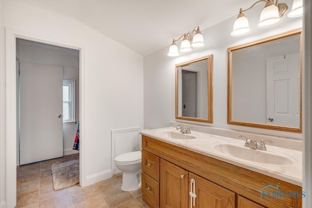 bathroom featuring vanity, vaulted ceiling, and toilet