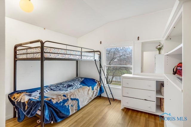 bedroom featuring lofted ceiling and light hardwood / wood-style flooring