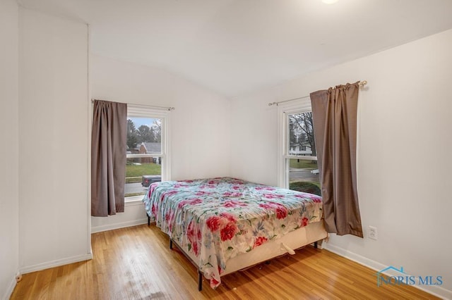 bedroom with hardwood / wood-style flooring and vaulted ceiling