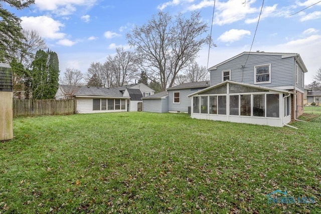 back of house with a lawn and a sunroom