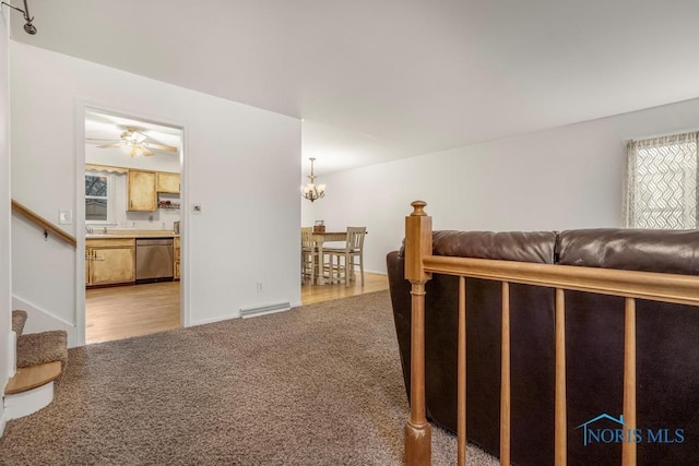 living room with sink, light hardwood / wood-style floors, and ceiling fan with notable chandelier