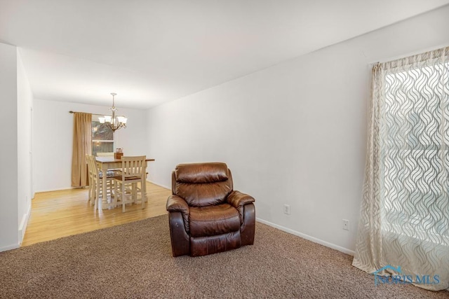 sitting room with hardwood / wood-style flooring and a notable chandelier