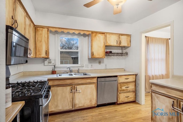 kitchen featuring ceiling fan, sink, light hardwood / wood-style floors, and appliances with stainless steel finishes