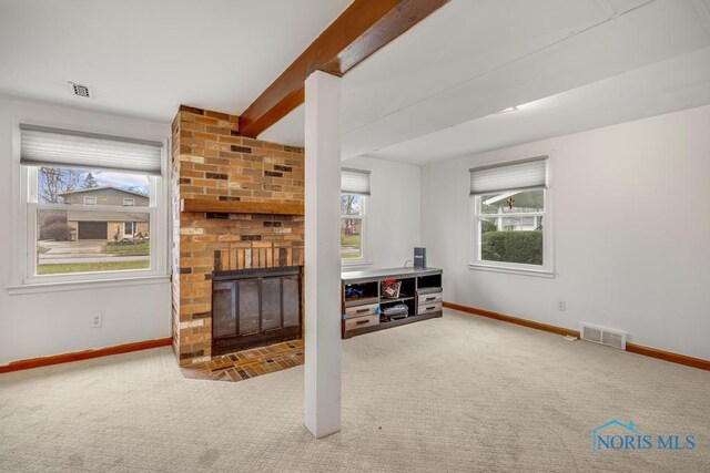 carpeted living room with a fireplace and a healthy amount of sunlight