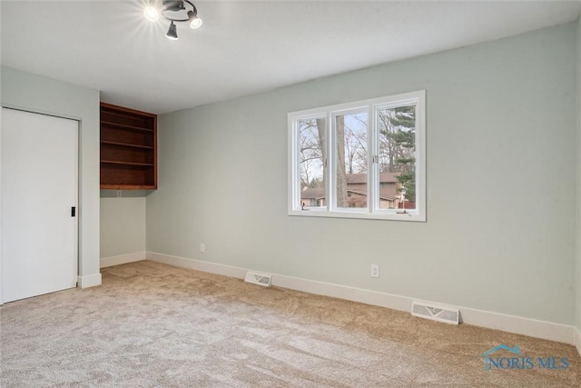 unfurnished bedroom with light carpet and a closet