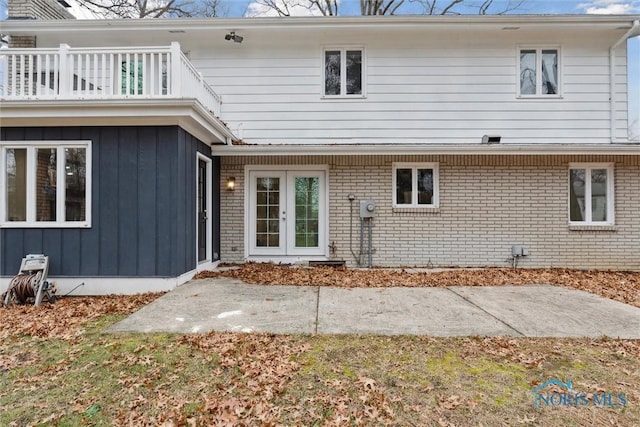 rear view of house featuring a balcony and french doors