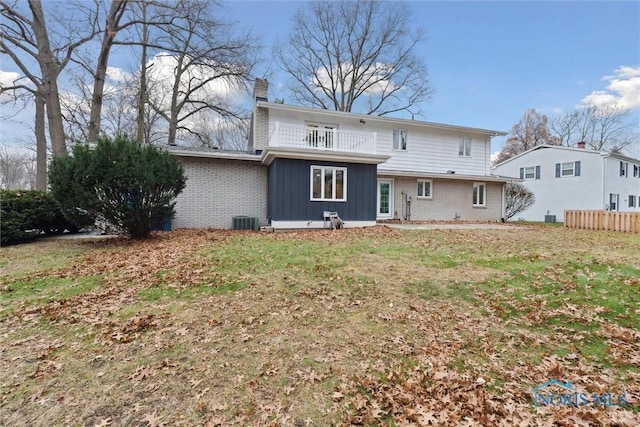 back of house with a yard, a balcony, and central AC unit