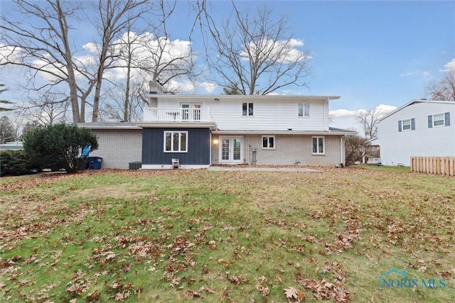 rear view of property featuring a lawn, french doors, and central AC unit