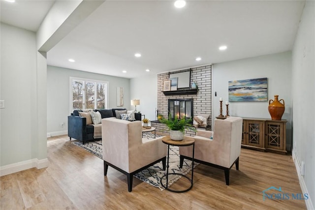 living room featuring light hardwood / wood-style floors and a brick fireplace