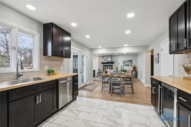 kitchen with butcher block countertops, wine cooler, sink, and stainless steel dishwasher