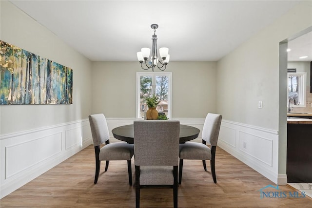 dining room featuring light hardwood / wood-style floors, sink, and a chandelier