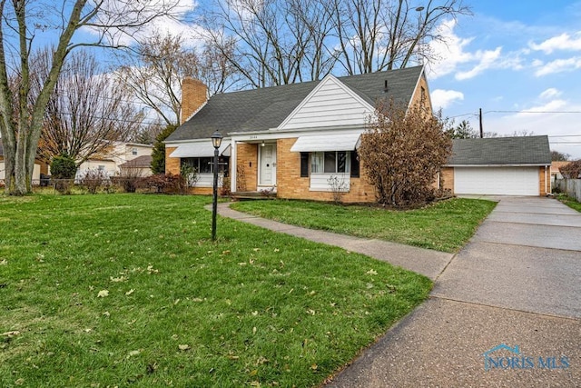 view of front of home with a garage, an outdoor structure, and a front lawn