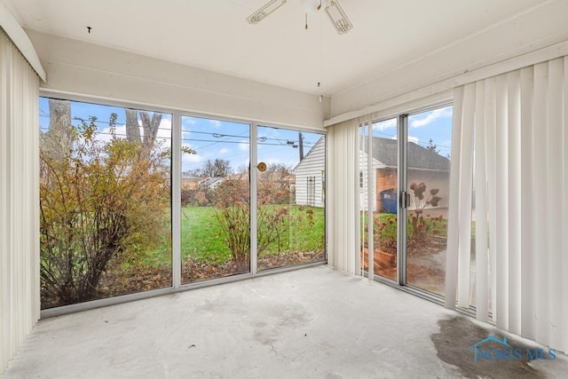 unfurnished sunroom featuring ceiling fan