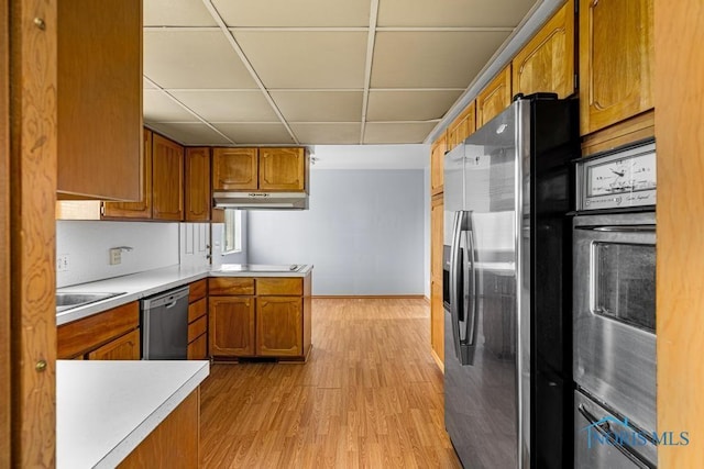 kitchen with a drop ceiling, stainless steel appliances, and light hardwood / wood-style flooring