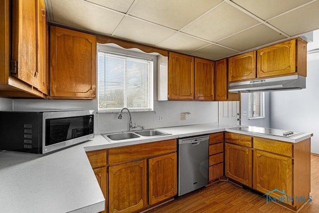 kitchen featuring hardwood / wood-style floors, a paneled ceiling, sink, kitchen peninsula, and stainless steel appliances