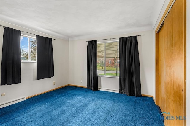 carpeted empty room featuring a baseboard radiator