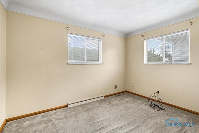 empty room with carpet flooring, a healthy amount of sunlight, and baseboard heating