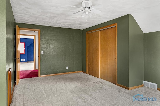 unfurnished bedroom with ceiling fan, a closet, carpet floors, and a textured ceiling