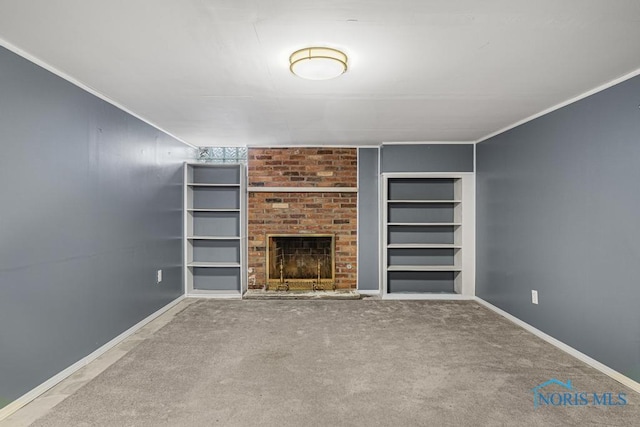 unfurnished living room featuring built in features, crown molding, carpet floors, and a fireplace