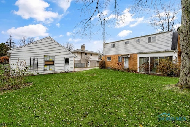 rear view of house featuring a yard