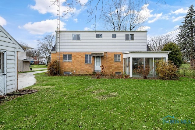 back of house featuring a sunroom and a lawn