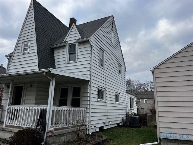 view of side of home with a porch and cooling unit