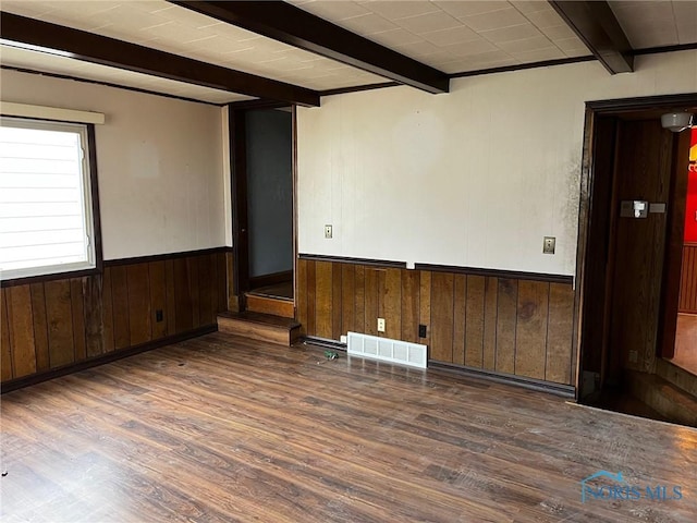 unfurnished room featuring beamed ceiling, dark hardwood / wood-style floors, and wooden walls