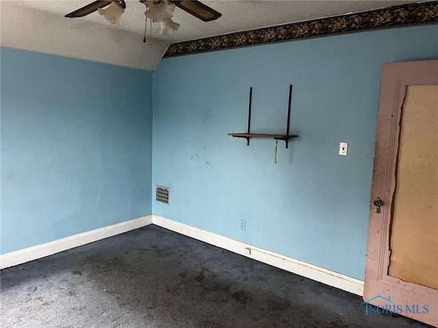 carpeted empty room with ceiling fan, lofted ceiling, and a textured ceiling