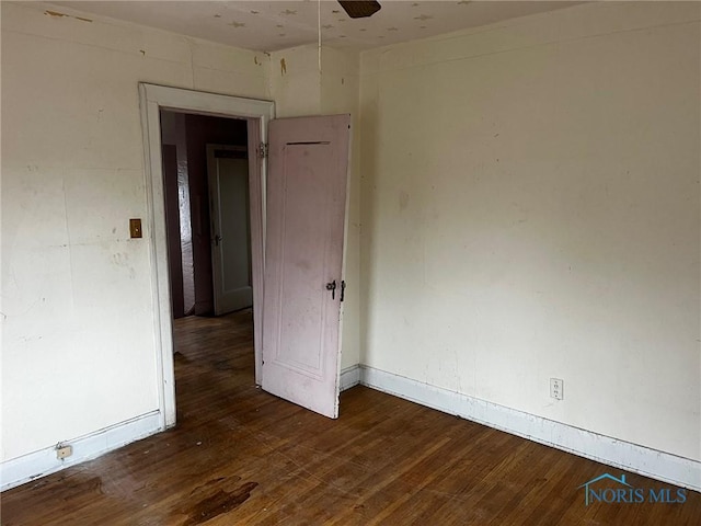 empty room with ceiling fan and dark hardwood / wood-style flooring