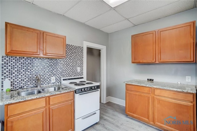 kitchen featuring light stone countertops, a drop ceiling, sink, white electric range oven, and light hardwood / wood-style floors