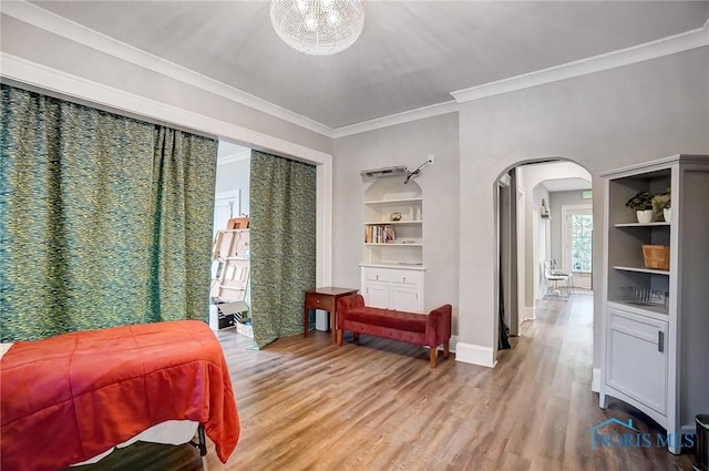 bedroom featuring a chandelier, hardwood / wood-style flooring, and ornamental molding