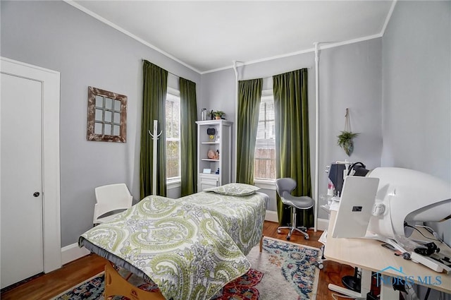 bedroom with hardwood / wood-style floors and ornamental molding