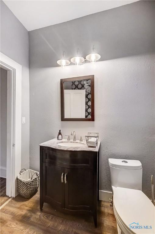 bathroom featuring hardwood / wood-style floors, vanity, and toilet