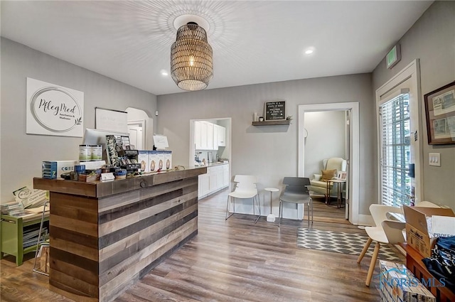 bar with white cabinets and hardwood / wood-style flooring