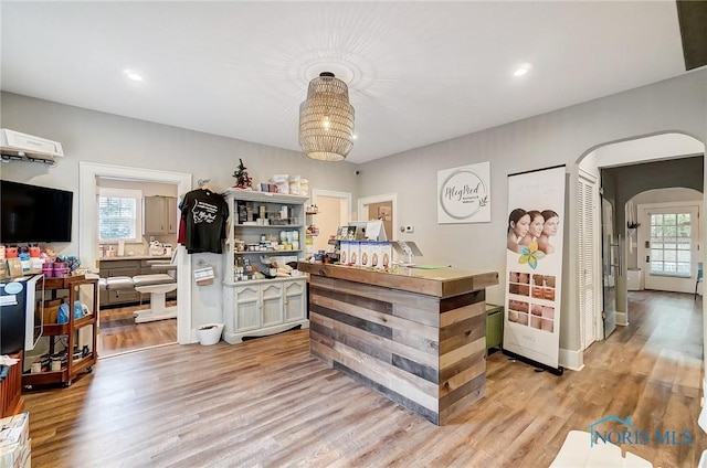 bar featuring light hardwood / wood-style flooring and a healthy amount of sunlight