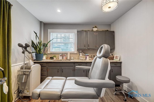 interior space featuring light stone countertops, gray cabinets, light hardwood / wood-style flooring, and sink