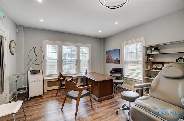 home office featuring radiator heating unit and light wood-type flooring