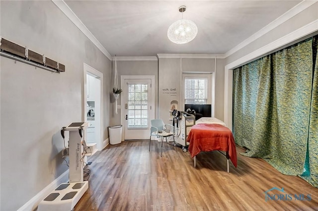 bedroom featuring hardwood / wood-style floors, a notable chandelier, and crown molding