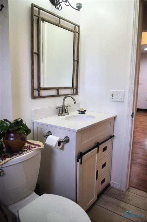 bathroom featuring hardwood / wood-style flooring, vanity, and toilet