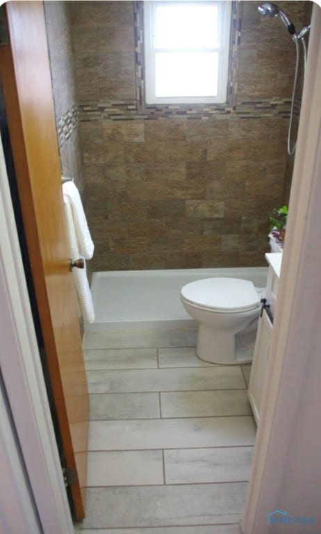 bathroom featuring vanity, toilet, and tiled shower