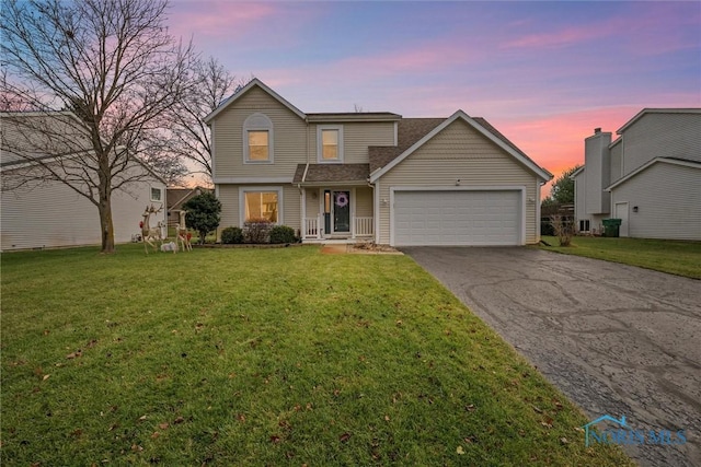 front of property with a yard and a garage