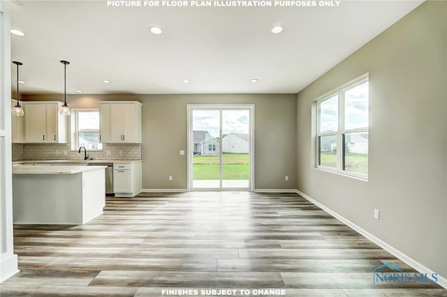 kitchen featuring dishwasher, light hardwood / wood-style flooring, tasteful backsplash, decorative light fixtures, and white cabinetry