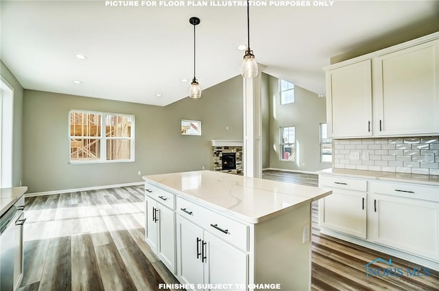 kitchen with pendant lighting, white cabinets, a fireplace, tasteful backsplash, and a kitchen island