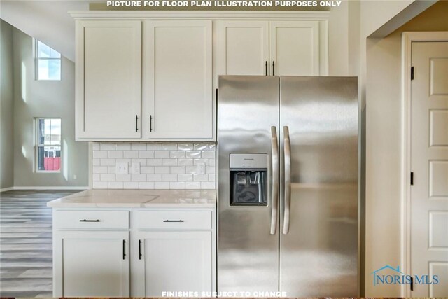 kitchen featuring white cabinets, decorative backsplash, light stone counters, and stainless steel refrigerator with ice dispenser