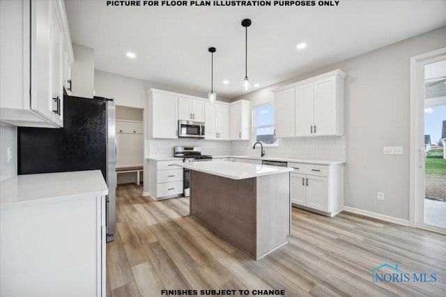 kitchen featuring white cabinets, a center island, appliances with stainless steel finishes, and pendant lighting