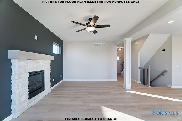 unfurnished living room featuring a stone fireplace, ceiling fan, and light hardwood / wood-style flooring